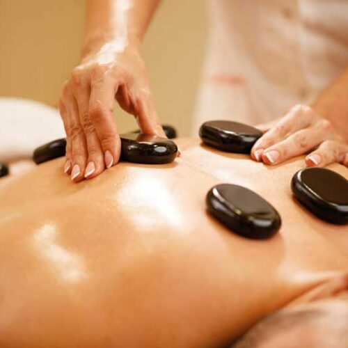 closeup-therapists-placing-hot-stones-man-s-back-during-lastone-therapy-spa-scaled-1